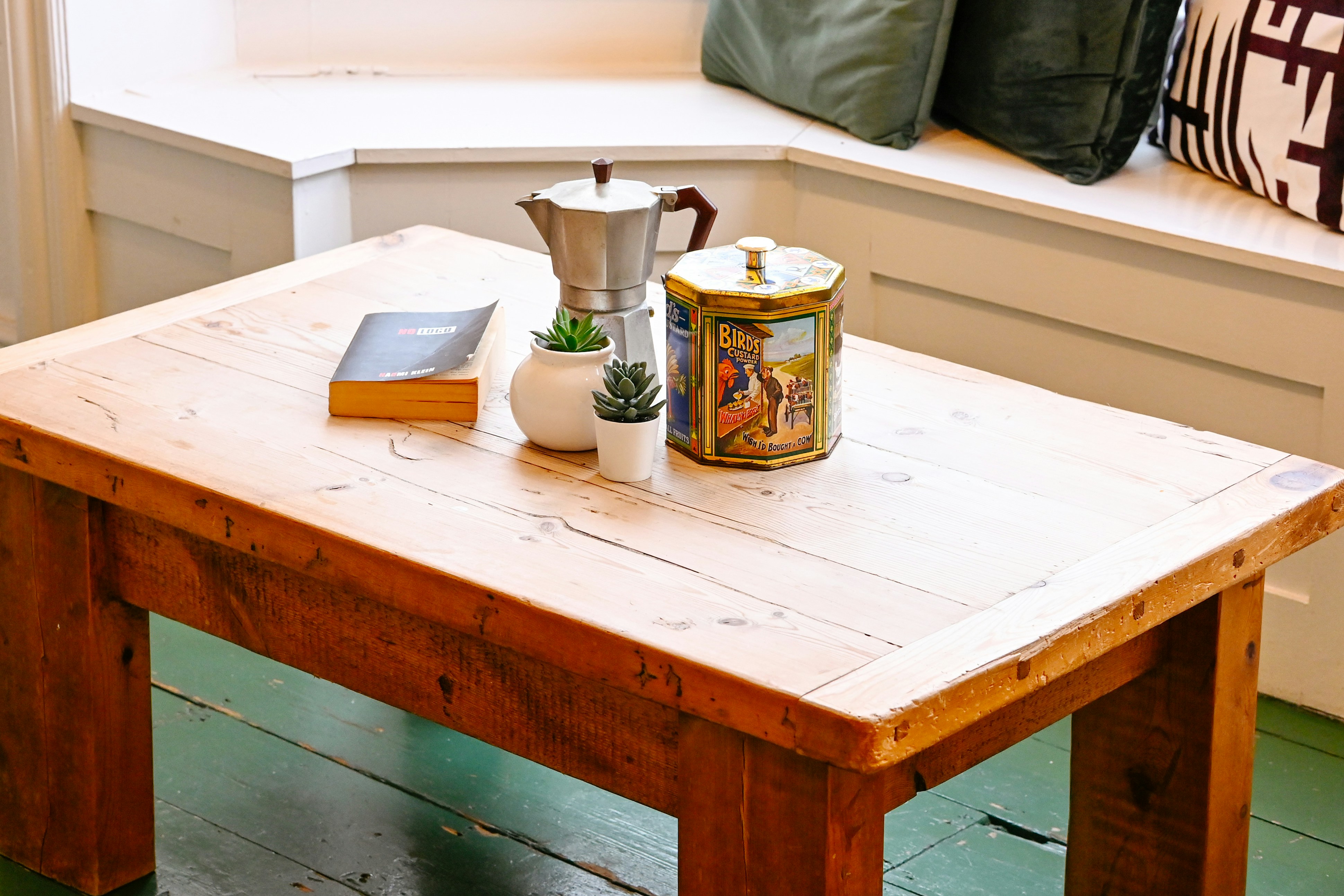 A wooden table with a book and a vase on it